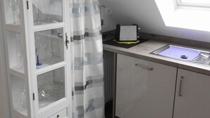 Una cocina con un mueble de vidrio, un tostador y una ventana con vistas.