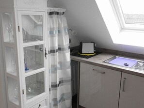 Keittiössä on lasikaappi, leivänpaahdin ja ikkuna, josta on näkymä.