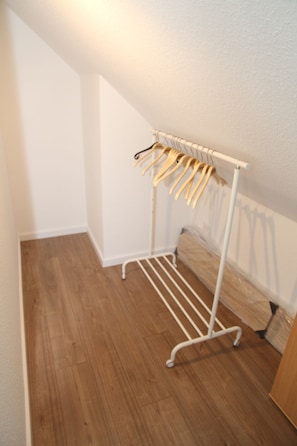 A white metal drying rack with wooden hangers against a wall in a room with wooden flooring. - Bei Ruhe - Beautiful vacation home in a fantastic waterfront location (Hinte)
