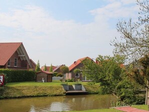 Ein Wohngebiet mit Häusern, einem Teich und einer kleinen Brücke.