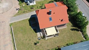 An aerial view of a house with a red roof, a covered porch, and a small garden. - MaiStern - High-quality vacation home (100sqm) for 6 people with fireplace, sauna & (Sternberg)