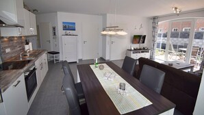 Una cocina moderna con comedor, televisor y vistas al exterior.
