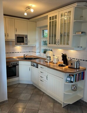 A kitchen with white cabinets, a microwave, a toaster, and a coffee maker.