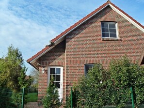 A brick house with a gabled roof, a small window, and a door. - Deichbrise - Deichbrise Vacation Home: A Relaxing Family Vacation in Greetsiel with (Krummhörn)