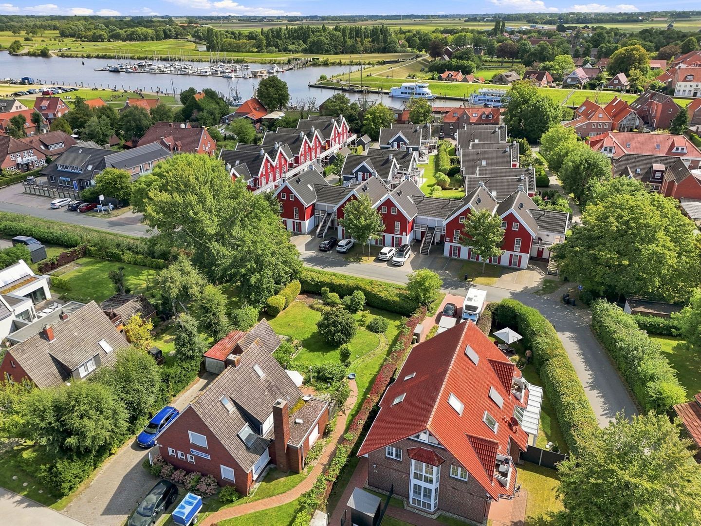 A residential area with houses, a marina, and a river.