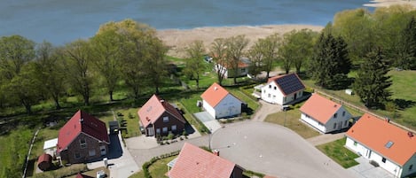 A residential area with houses, a large body of water, and a sandy beach.