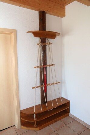 Ein Eckzimmer mit einer Holzregaleinrichtung an der Wand, einer Tür und gefliestem Boden.