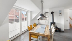 Un loft moderno con comedor, cocina y un dormitorio elevado con tragaluz.