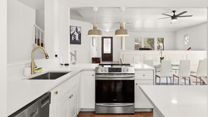 A modern kitchen with white cabinetry, stainless steel appliances, and pendant lighting. - Modern 5 Bedrooms in SA Chef Kitchen, Game Lounge (San Antonio)
