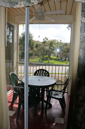 Enjoy a quiet moment on this balcony with a table for four and a ceiling fan above.