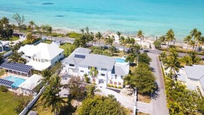 Uma área residencial costeira com casas, uma piscina e vista clara para o oceano.