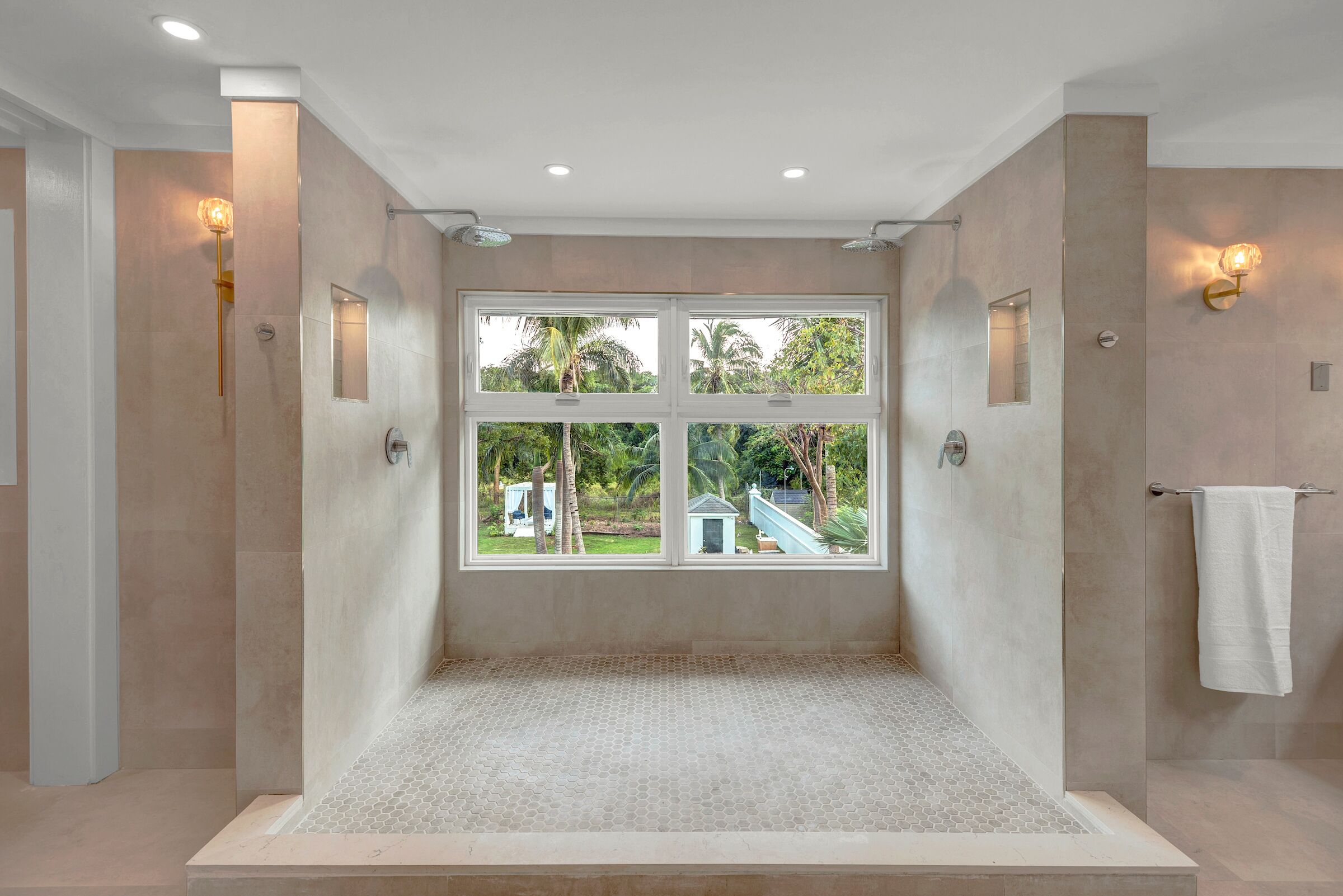 A modern bathroom with a large window, a shower area, and a towel rack.