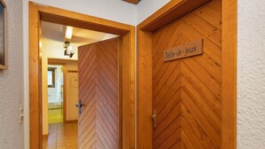 A hallway with wooden doors, one labeled 'Salle-de-jEUX'. - Centaure B RI 1 by Interhome (Ovronnaz)