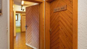 Un couloir avec des portes en bois, dont une porte sur laquelle est inscrit « Salle de jeux ».
