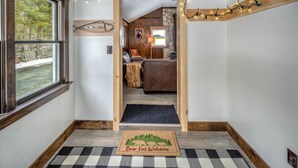 Un interno accogliente con una panca in legno, un camino e vista sull'esterno.