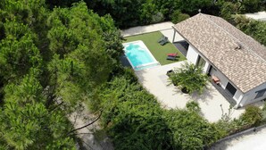 An aerial view of a house with a swimming pool, surrounded by dense greenery. - La Villa Beau Soleil (Saint-Julien-de-Peyrolas)