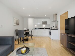 A modern apartment with a dining area, kitchen, living room, and a TV. - Amber Court 1 by Interhome (Canary Wharf)