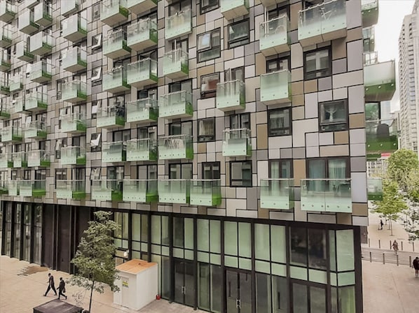 A modern building with a grid of balconies and large windows.