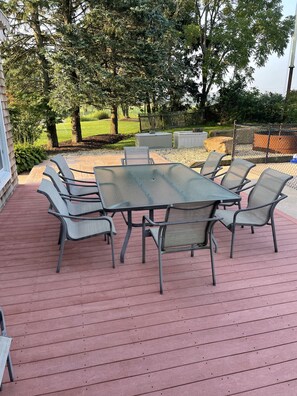 Relax in a serene outdoor space surrounded by lush greenery and comfortable seating for six.