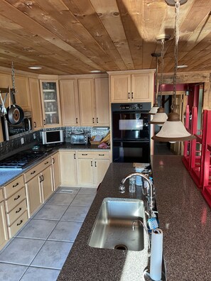Enjoy cooking in this well-equipped kitchen with a large island, stove, oven, and sink.