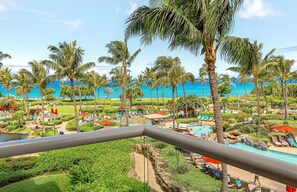 Un complexe hôtelier doté d’une piscine, de palmiers et offrant une vue sur l’océan.