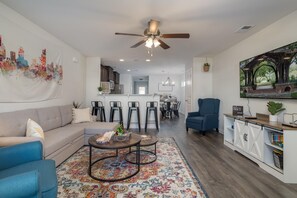Relax in this stylish living space with a sofa, armchair, and coffee table, perfect for unwinding and enjoying the view.
