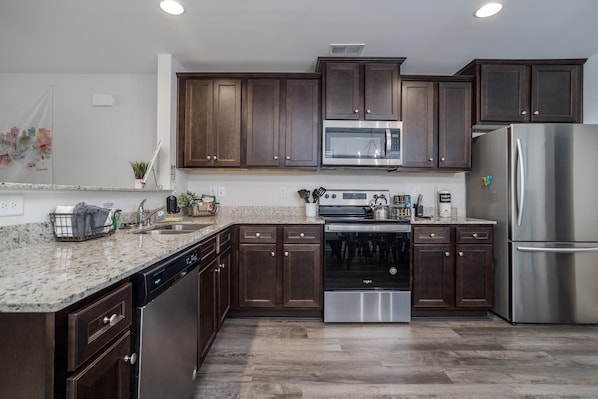 Enjoy cooking in this well-equipped kitchen with a refrigerator, microwave, dishwasher, double oven, and sink.