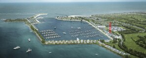 An aerial view of a marina with boats, a large building, and surrounding greenery. - Holiday Apartment "Reeders Topp by Seeblick Ferien" with Harbour View (OstseeResort Olpenitz)