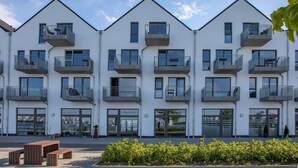 A modern multi-story building with balconies, large windows, and a clear sky. - Holiday Apartment "Reeders Topp by Seeblick Ferien" with Harbour View (OstseeResort Olpenitz)