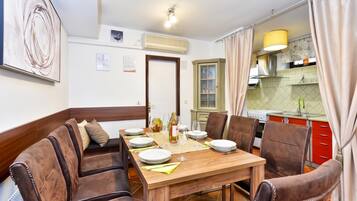 A dining area with a wooden table set for four, surrounded by leather chairs.