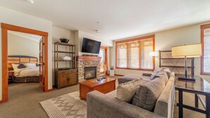 A living room with a fireplace, a television, a sofa, and a dining area.