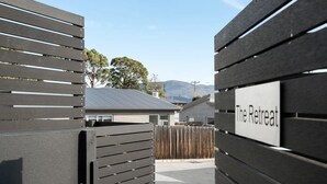 A gated entrance labeled "The Retreat" with a view of residential buildings and a mountain in the background.