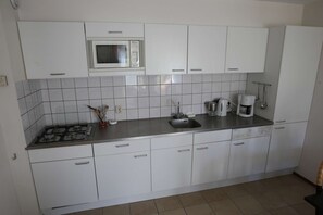 Een koelkast, een magnetron, een oven, een koffiezetapparaat/waterkoker