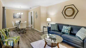 A living room with a sofa, armchairs, a coffee table, and a dining area with chairs and a table. - San Antonio Home: Near Nature, Parks & Trails (San Antonio)