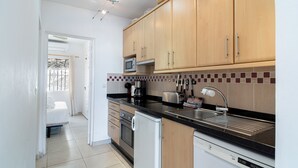 Une cuisine moderne avec des meubles en bois, un four à micro-ondes, un grille-pain et un lave-vaisselle.