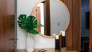A modern bathroom with a wooden vanity, a round mirror, and a potted plant. - ✨ Luxurious 3-Bedroom Apartment with Pool & 24/7 security  (Santiago De Los Caballeros)