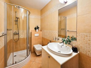 Une salle de bain moderne avec une douche à parois de verre, un lavabo blanc et des toilettes.