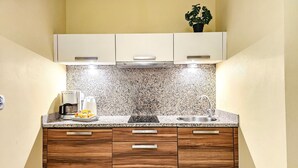 Une cuisine dotée d’un plan de travail en granit, de meubles en bois et d’un évier en acier inoxydable.