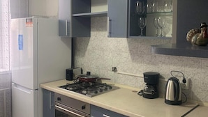 A compact kitchen with a refrigerator, stove, and sink. - Lovely Brand New Apartment with 2 Rooms and Balcony  (Chișinău)