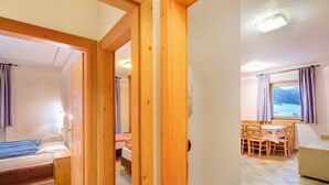 Une pièce avec un lit, une petite table et une fenêtre avec des rideaux.