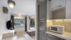 A modern kitchen with a microwave, cabinets, and a dining area with a table and chairs.