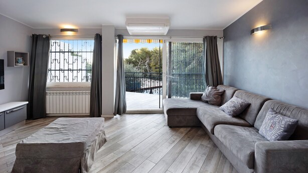 A modern living room with a sofa, a bench, and a TV.