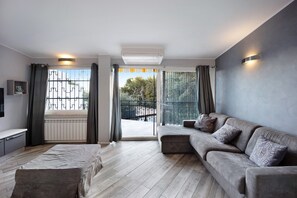 A modern living room with a sofa, a bench, and a TV.