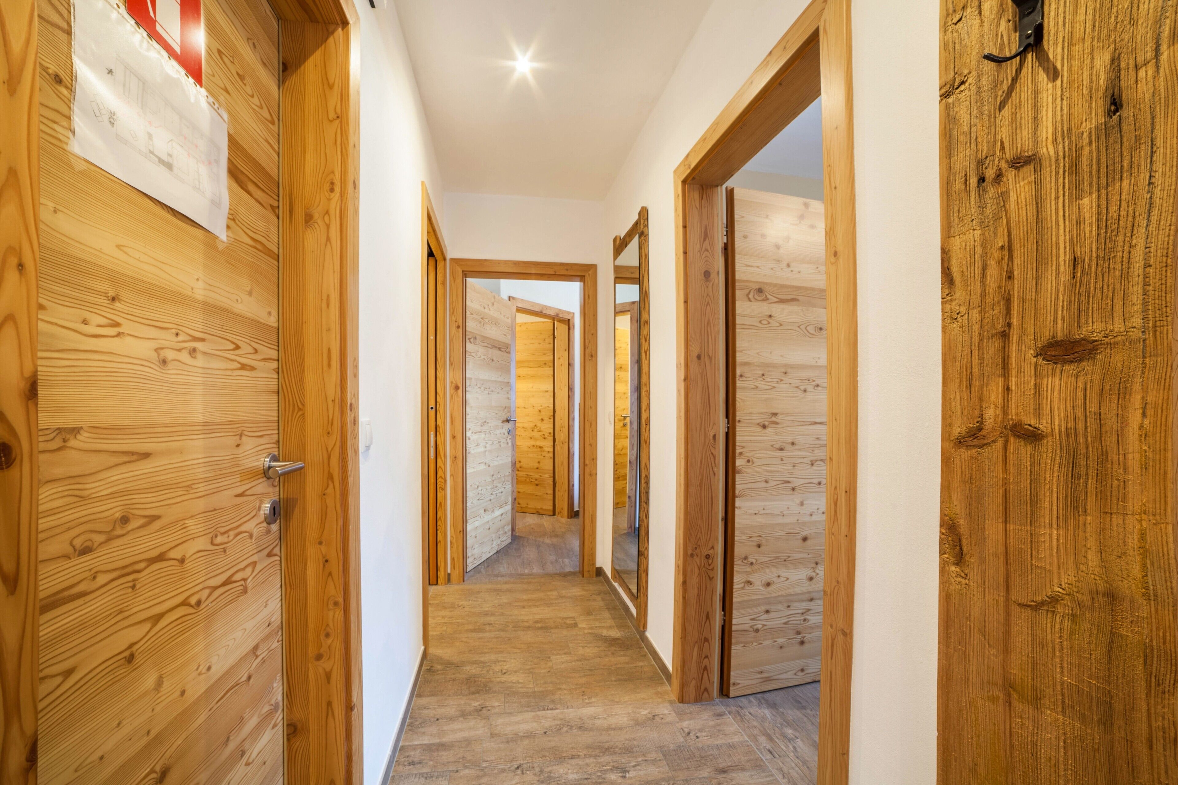 A wooden hallway with doors leading to other rooms.