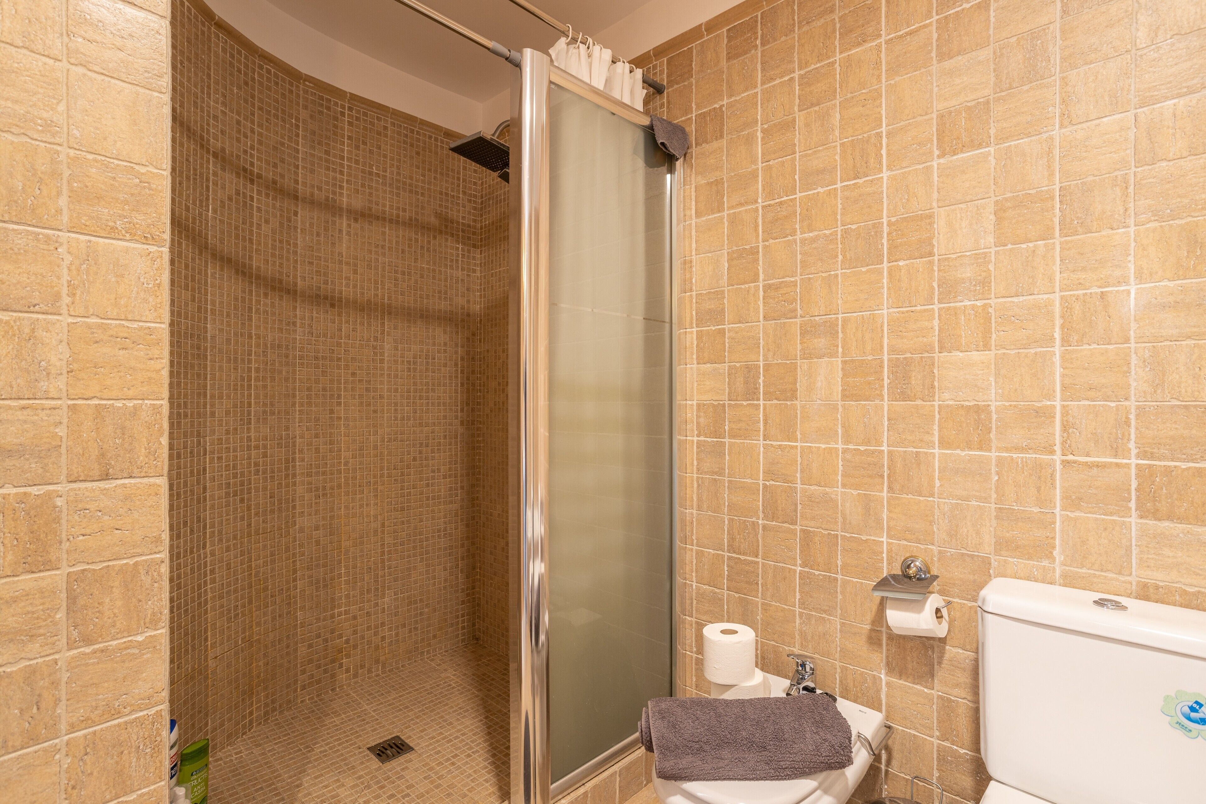A bathroom with a shower, toilet, and sink.