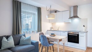 Una cocina moderna con armarios blancos, una estufa y un comedor con mesa y sillas.
