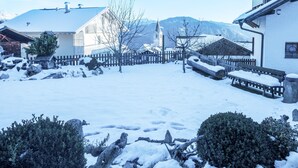 Un barrio residencial cubierto de nieve, con casas, una valla de madera y un banco.