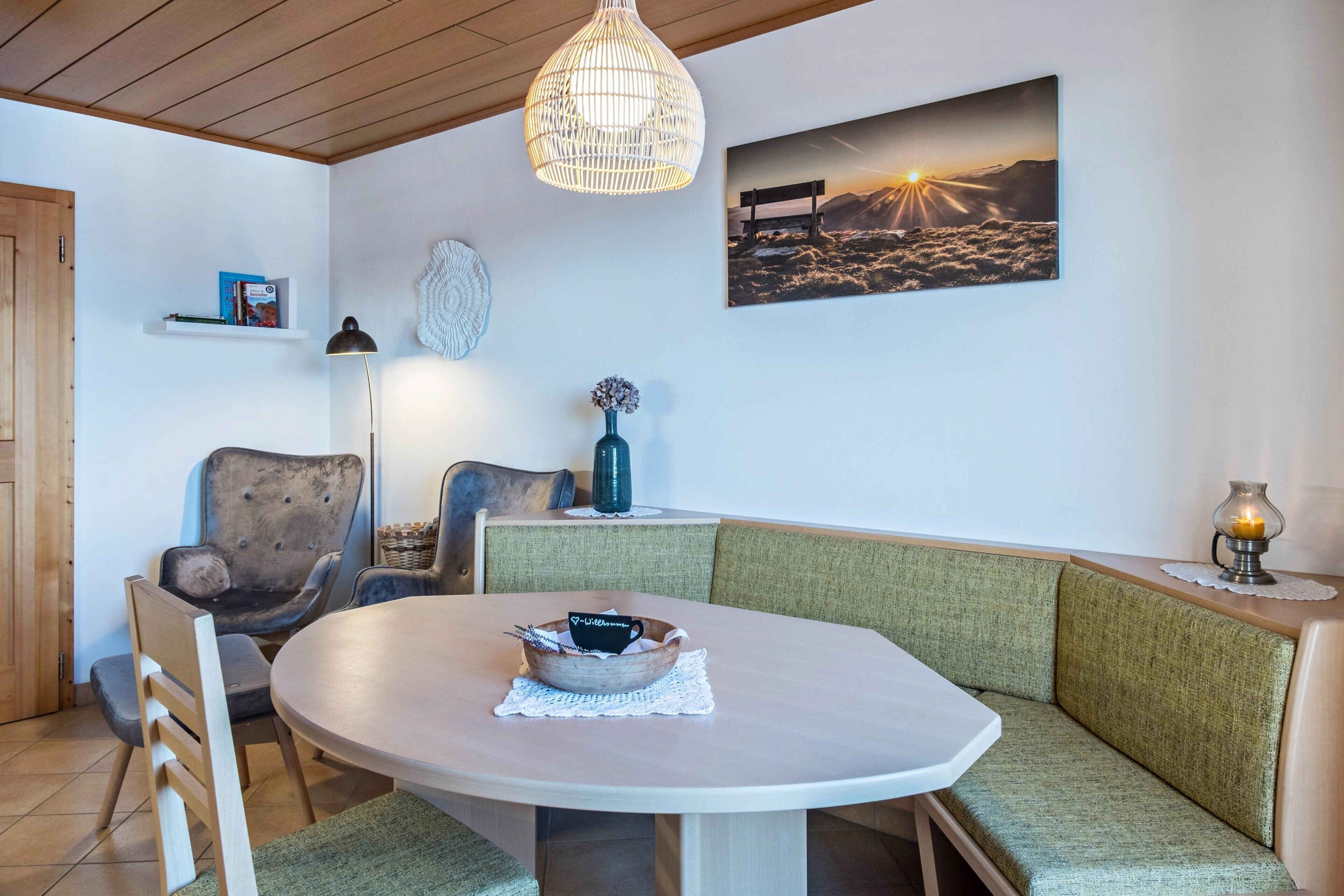 Un coin repas accueillant avec une table ronde, un banc rembourré et une suspension.