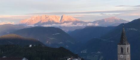 Un paysage de montagne avec un clocher d’église et des immeubles d’habitation.