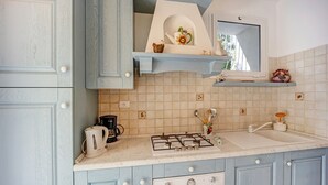 A kitchen with light blue cabinets, a gas stove, a sink, and a window above the countertop. - Holiday Home 'Paola E Del Poeta' with Shared Pool, Private Garden and Wi-Fi (Dolcedo)